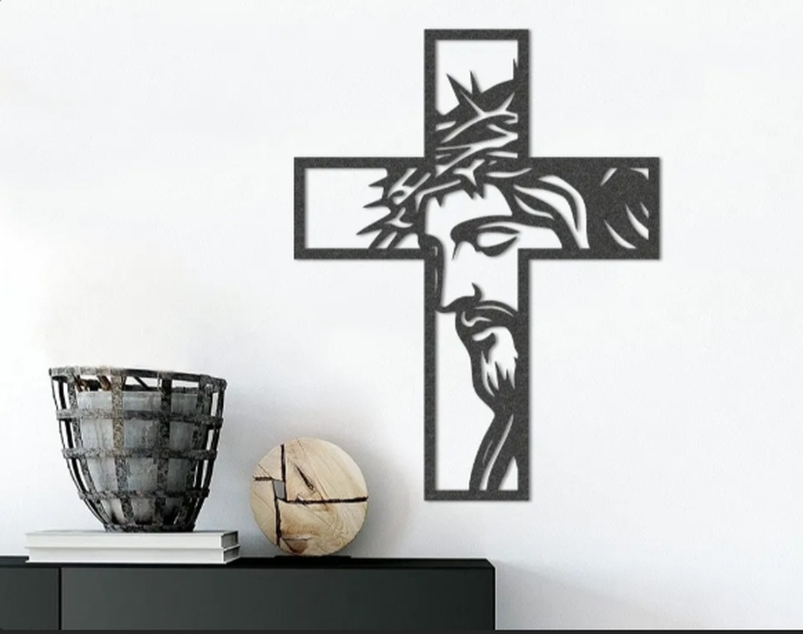 Painel vazado de parede com o rosto de Cristo dentro de uma cruz, impresso em 3D e instalado sobre um aparador.