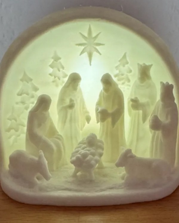 Presépio impresso em 3D em material translúcido, iluminado por trás, com a Sagrada Família, os reis magos e os animais.